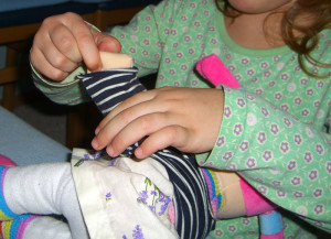 Obliekanie bábik, montessori obliekacie rámy, montessori zapínacie rámy, montessori prestieranie, montessori aktivity praktického života